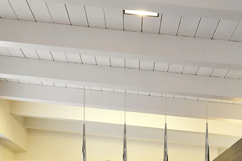 Holzbalken an weißer Decke